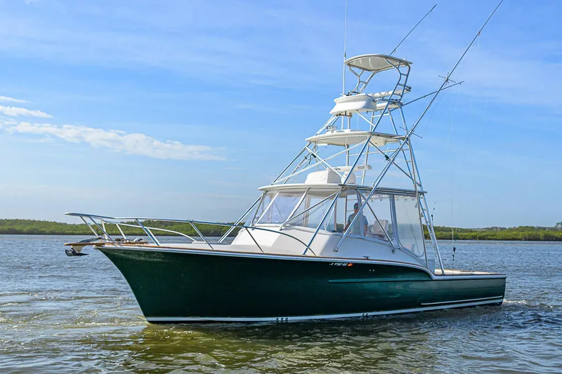 Slide: The Image of 2008 Jersey Cape Devil 36 boat on calm water, featuring a sleek design and fishing tower. - 2