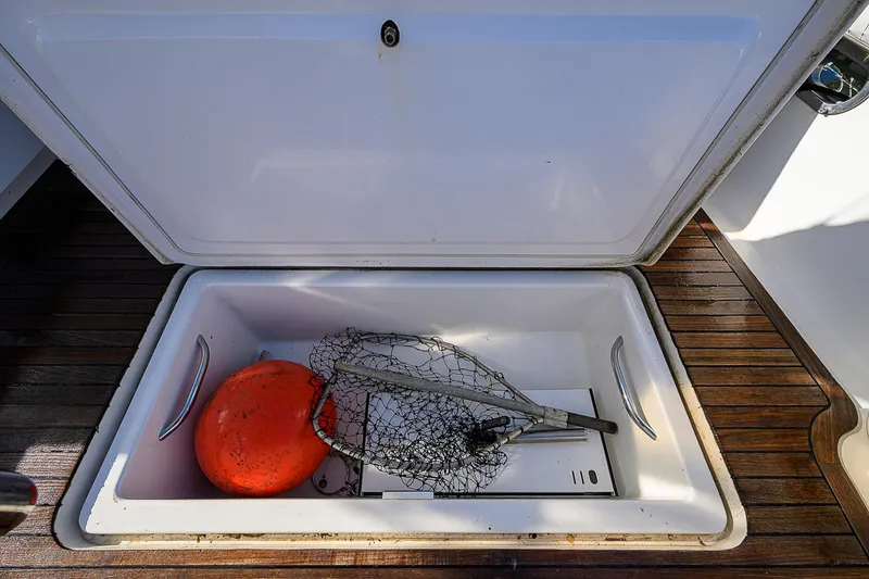 Slide: The Image of Open storage compartment on 2008 Jersey Cape Devil 36 boat with fishing gear and buoy. - 24