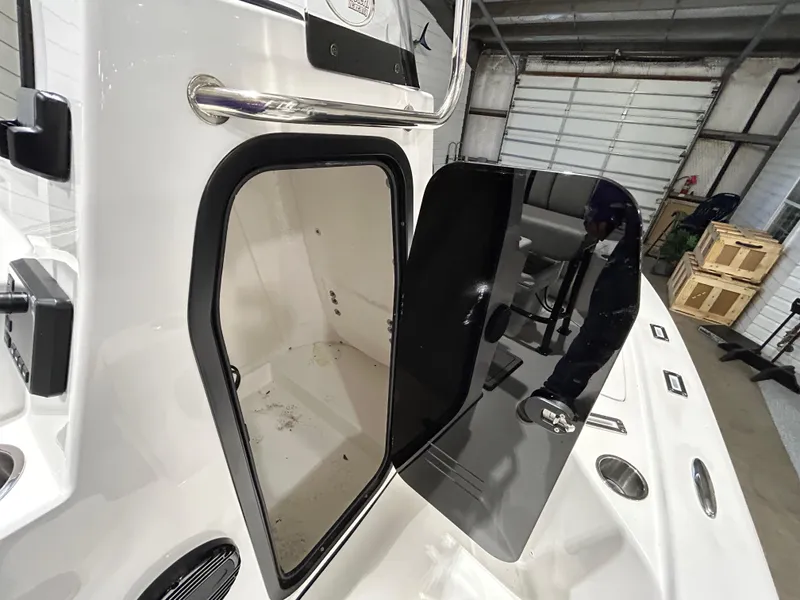 Slide: The Image of 2025 Sea Pro 210 Bay boat interior with open hatch in a garage setting. - 11