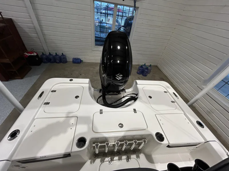 Slide: The Image of 2025 Sea Pro 210 Bay boat with outboard motor in a garage setting. - 13