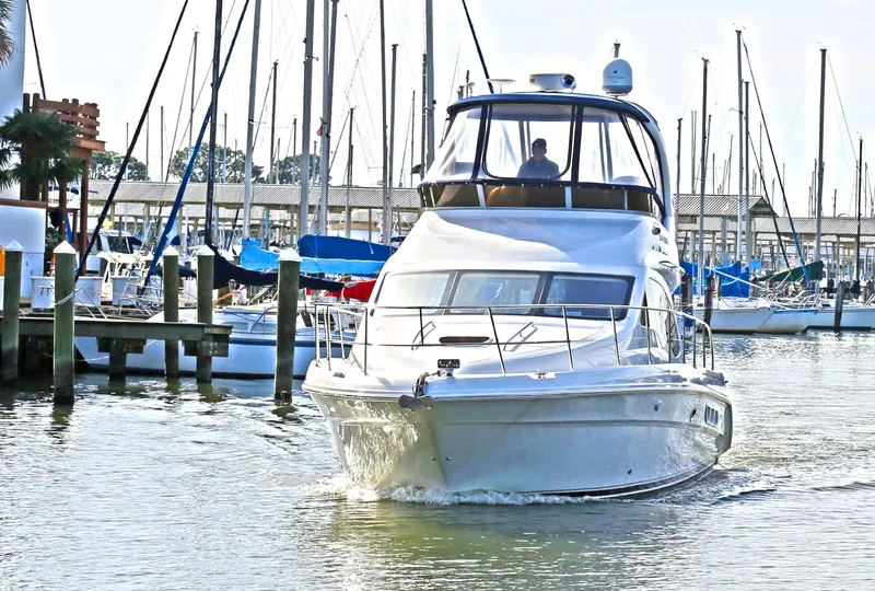 Slide: The Image of 2007 Sea Ray 44 Sedan Bridge yacht navigating marina waters. - 2