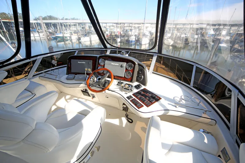 Slide: The Image of 2007 Sea Ray 44 Sedan Bridge helm with modern controls and panoramic marina view. - 27