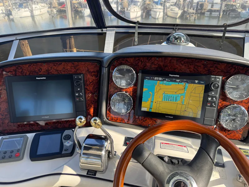 Slide: The Image of 2007 Sea Ray 44 Sedan Bridge helm with navigation screens and controls. - 28