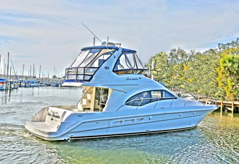 Slide: The Image of 2007 Sea Ray 44 Sedan Bridge yacht on calm water near marina. - 3