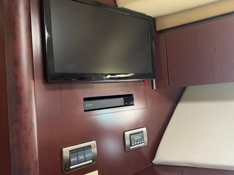 Slide: The Image of 2007 Sea Ray 44 Sedan Bridge interior with wall-mounted TV and control panels. - 48