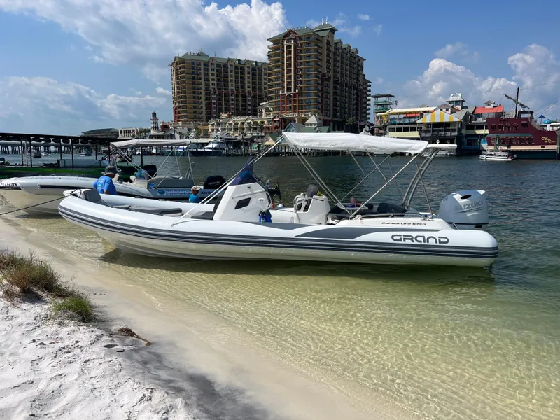 Slide: The Image of 2024 Grand G750 boat docked on sandy beach with cityscape background. - 3