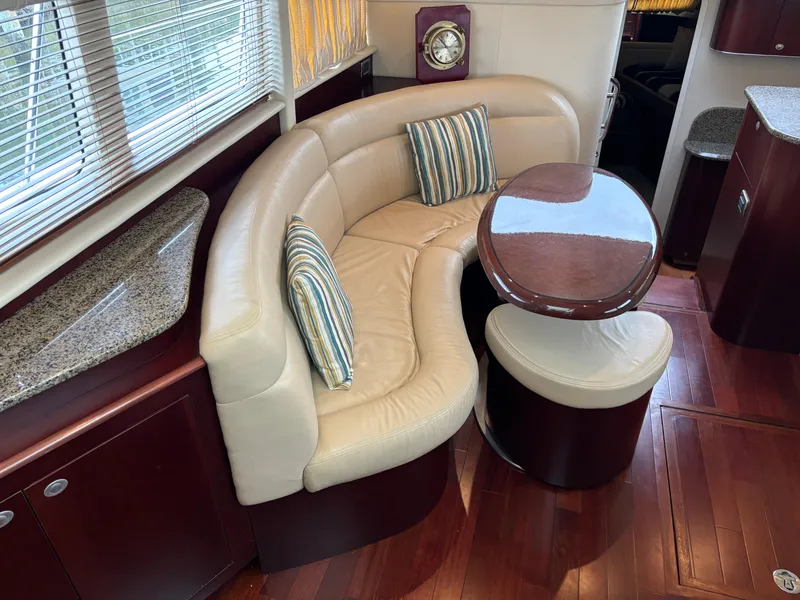 Slide: The Image of Luxurious 2006 Sea Ray 40 Motor Yacht interior with curved leather seating and elegant wood finishes. - 15