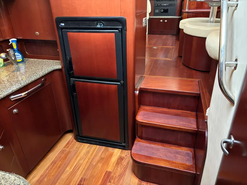 Slide: The Image of Interior of 2006 Sea Ray 40 Motor Yacht with wooden flooring and compact kitchen area. - 20
