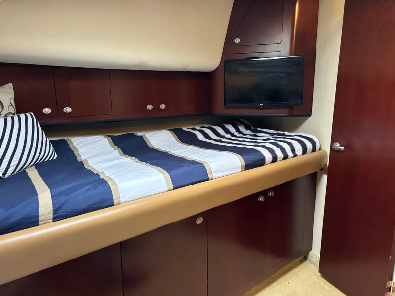 Slide: The Image of Luxurious 2006 Sea Ray 40 Motor Yacht cabin with striped bedding and wood cabinetry. - 23
