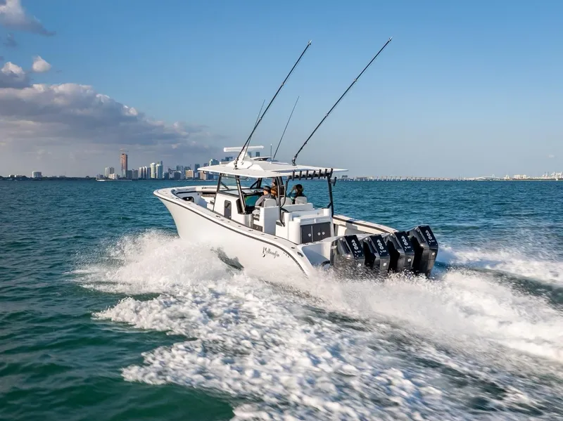 Slide: The Image of 2024 Yellowfin 42 boat cruising on open water with city skyline in background. - 14