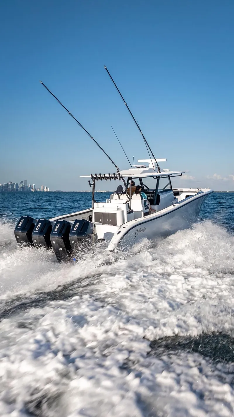 Slide: The Image of 2024 Yellowfin 42 boat cruising on open water with city skyline in background. - 16