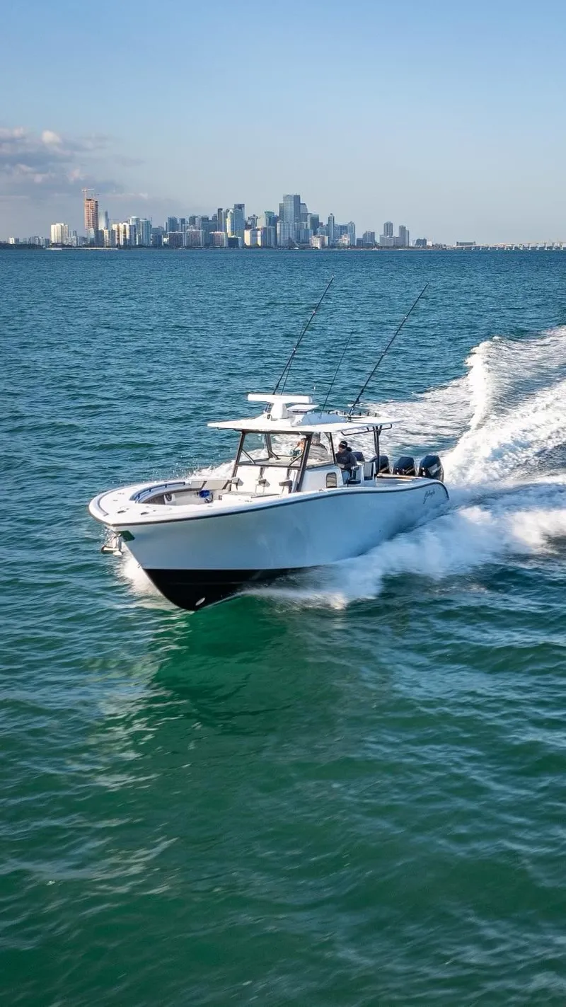 Slide: The Image of 2024 Yellowfin 42 boat cruising on ocean with city skyline in background. - 4