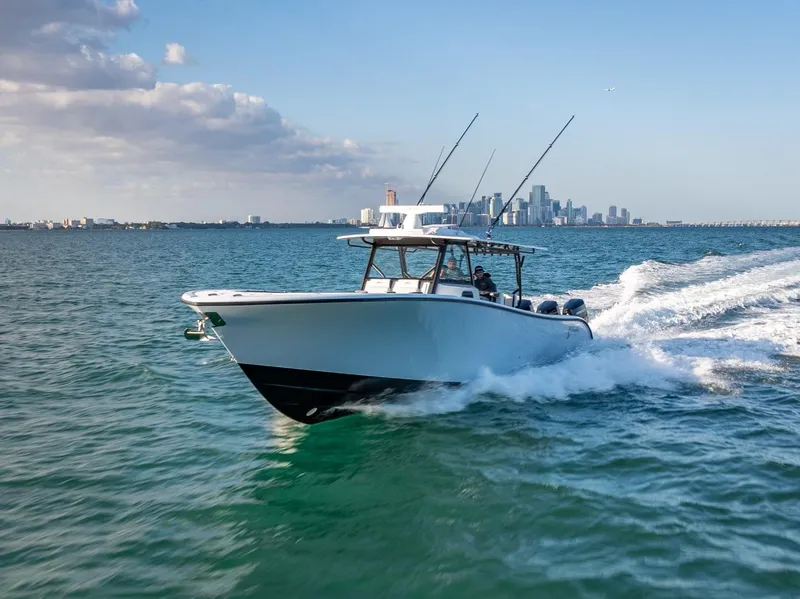 Slide: The Image of 2024 Yellowfin 42 boat cruising on open water with city skyline in background. - 5