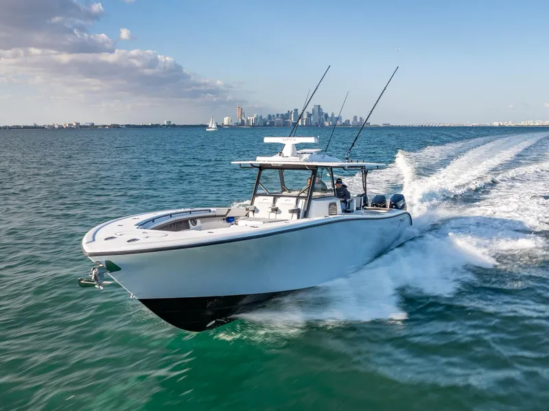 Slide: The Image of 2024 Yellowfin 42 boat cruising on open water with city skyline in background. - 7