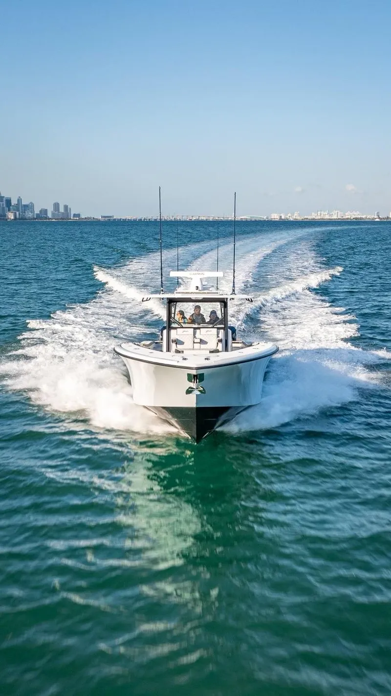 Slide: The Image of 2024 Yellowfin 42 boat cruising on open water with city skyline in background. - 9