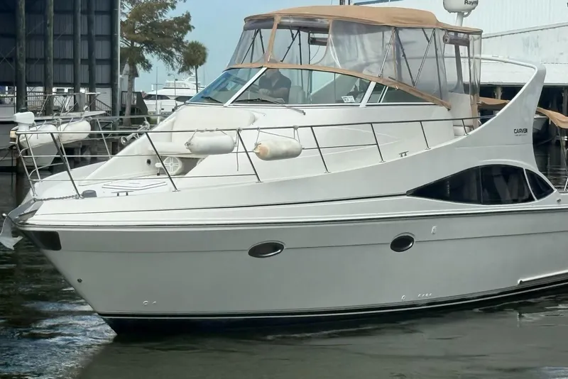 Slide: The Image of 2004 Carver 360 Mariner yacht docked in marina, featuring sleek design and spacious deck. - 2