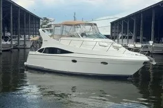 The Image of 2004 Carver 360 Mariner yacht docked in a marina, surrounded by water and covered slips. - 0