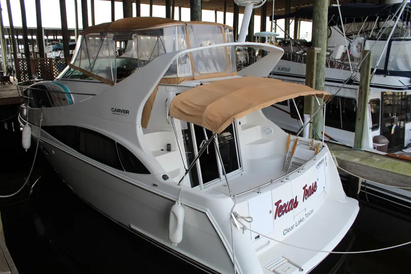 Slide: The Image of 2004 Carver 360 Mariner yacht docked, featuring beige canopy and sleek design. - 4