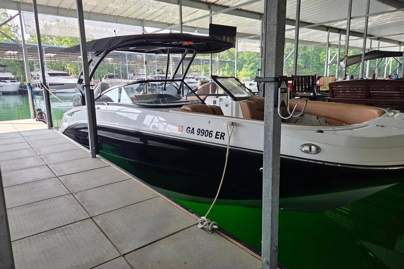 Slide: The Image of 2025 Hurricane SunDeck 2600 OB boat docked, featuring sleek design and spacious seating. - 11