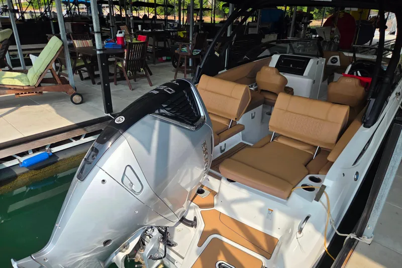 Slide: The Image of 2025 Hurricane SunDeck 2600 OB boat with tan seating and powerful outboard motor. - 12