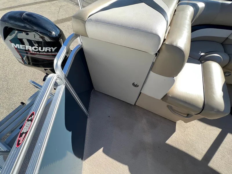 Slide: The Image of 2013 Harris FloteBote Cruiser interior with Mercury outboard motor, beige seating, and carpeted floor. - 18