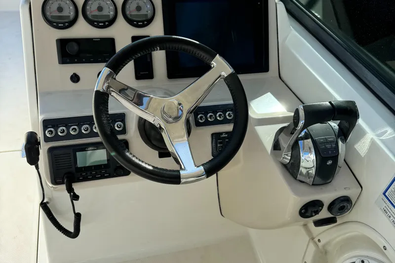 Slide: The Image of 2014 Boston Whaler 270 Vantage boat dashboard with steering wheel and controls. - 26