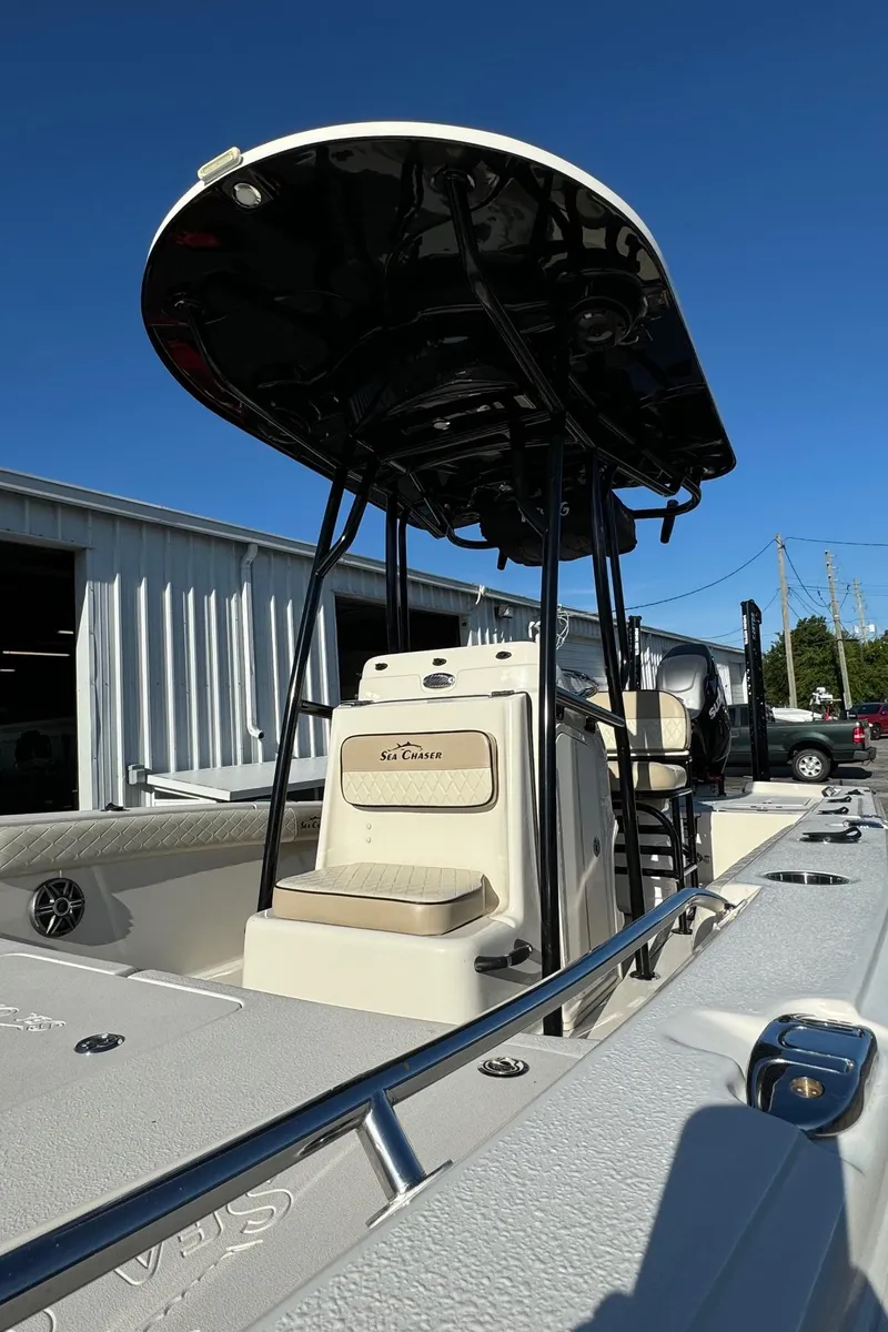 Slide: The Image of 2021 Sea Chaser 26LX boat with T-top, docked under clear blue sky. - 10