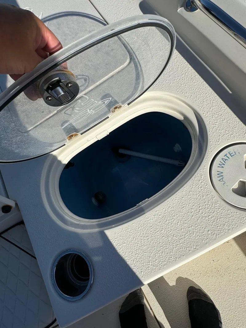 Slide: The Image of 2021 Sea Chaser 26LX livewell with open lid, showing interior and raw water access. - 15