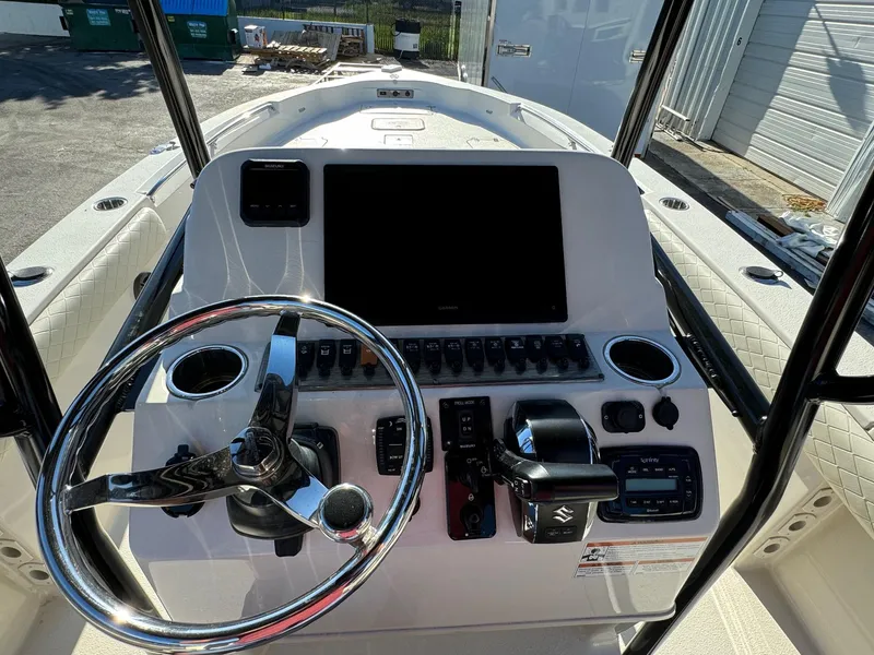 Slide: The Image of 2021 Sea Chaser 26LX boat dashboard with steering wheel and control panel. - 16