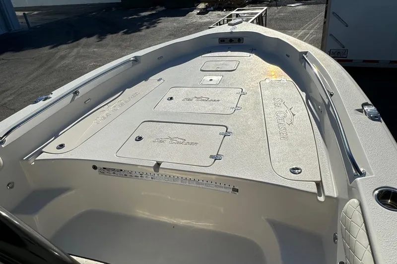 Slide: The Image of 2021 Sea Chaser 26LX boat deck with storage compartments, sunlight reflecting on surface. - 22