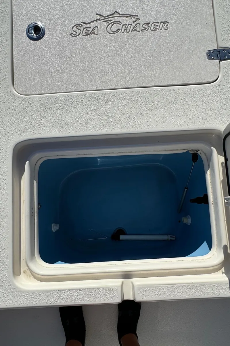 Slide: The Image of 2021 Sea Chaser 26LX boat compartment with open hatch, showcasing interior storage space. - 30