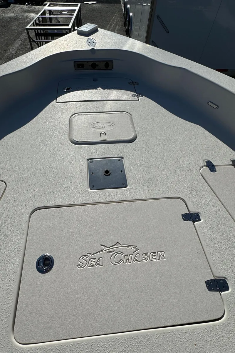 Slide: The Image of 2021 Sea Chaser 26LX boat deck with storage compartments and logo. - 31