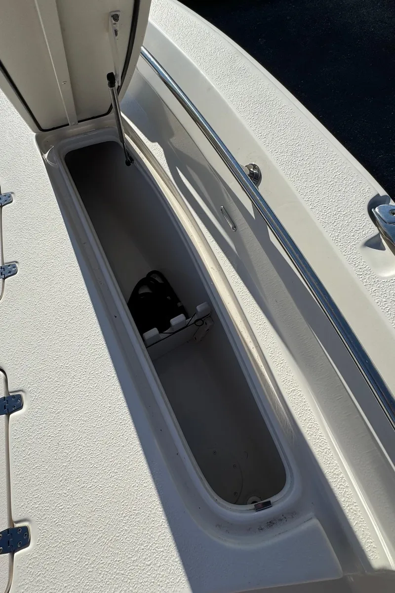 Slide: The Image of 2021 Sea Chaser 26LX boat storage compartment, open lid, white interior. - 34