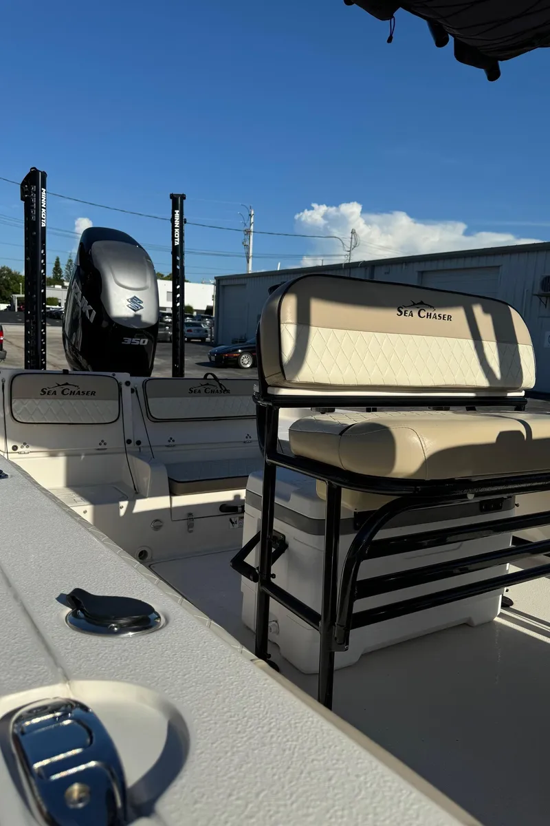 Slide: The Image of 2021 Sea Chaser 26LX boat interior with seating and engine, under clear blue sky. - 39