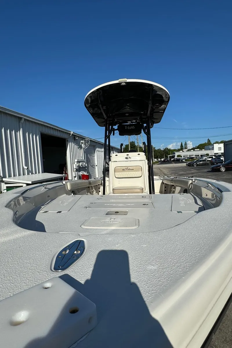 Slide: The Image of 2021 Sea Chaser 26LX boat with T-top, docked under clear blue sky. - 9