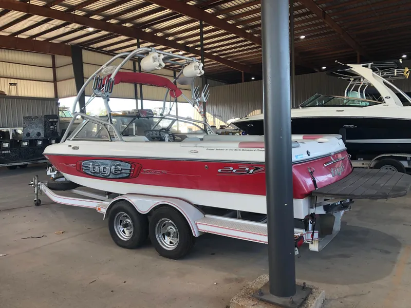 Slide: The Image of 2004 Tigé 22I TYPE R boat in storage, red and white design, on a trailer. - 2