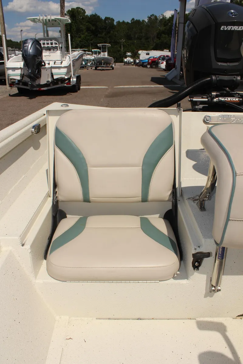 Slide: The Image of 2020 Alumacraft 20 Coastal Bay boat seat with teal accents in a marina setting. - 19