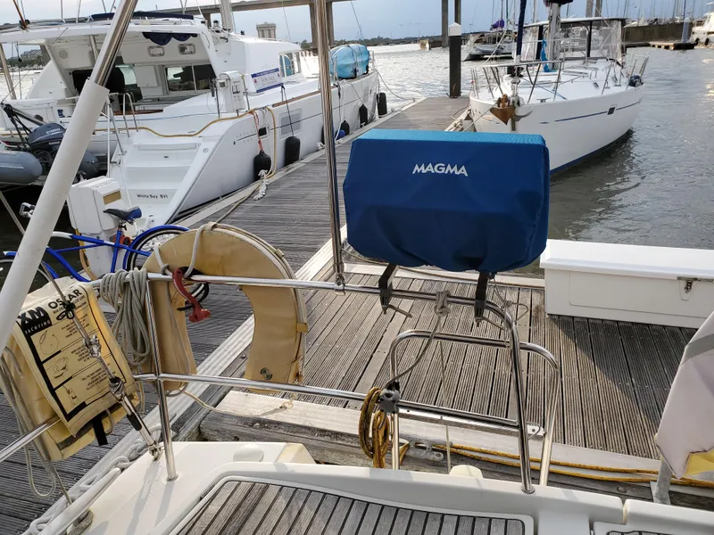 Slide: The Image of Beneteau 43 sailboat docked, featuring a Magma grill and nautical equipment, 2008 model. - 10