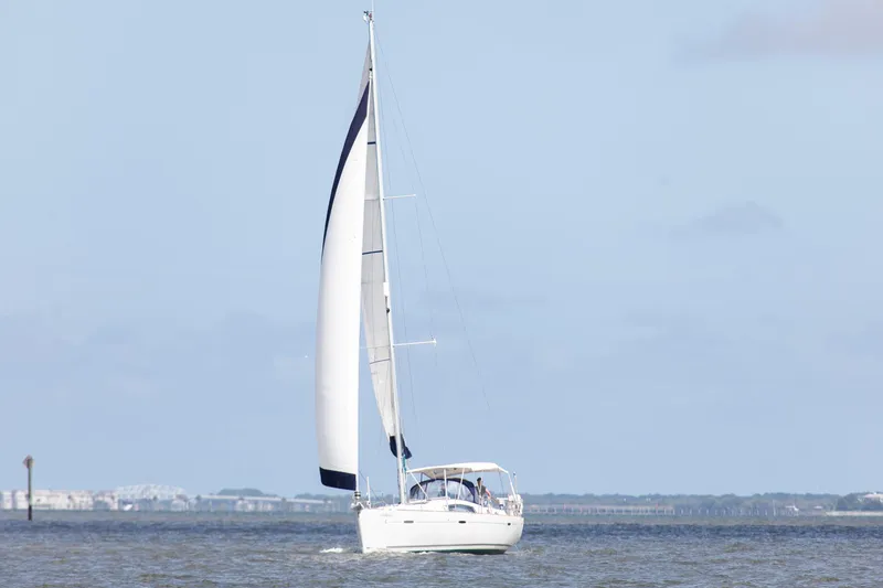 Slide: The Image of 2008 Beneteau 43 sailboat cruising on open water under clear skies. - 2