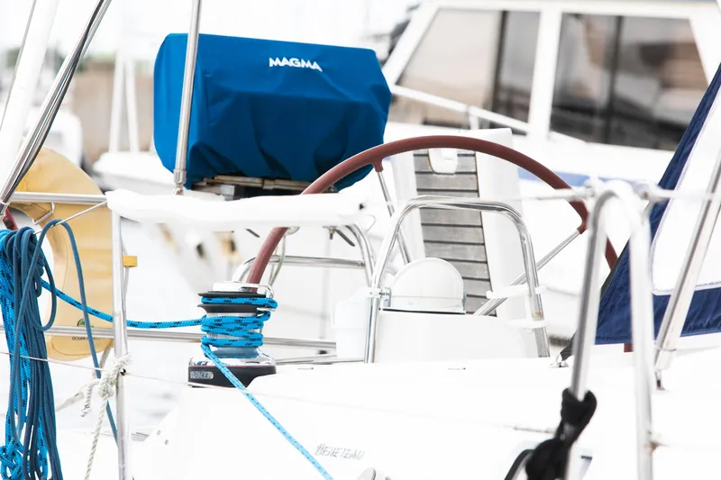 Slide: The Image of Beneteau 43 sailboat cockpit with blue ropes and covered equipment, 2008 model. - 28