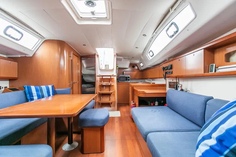 Slide: The Image of Interior of 2008 Beneteau 43 yacht with blue seating and wooden finishes. - 34