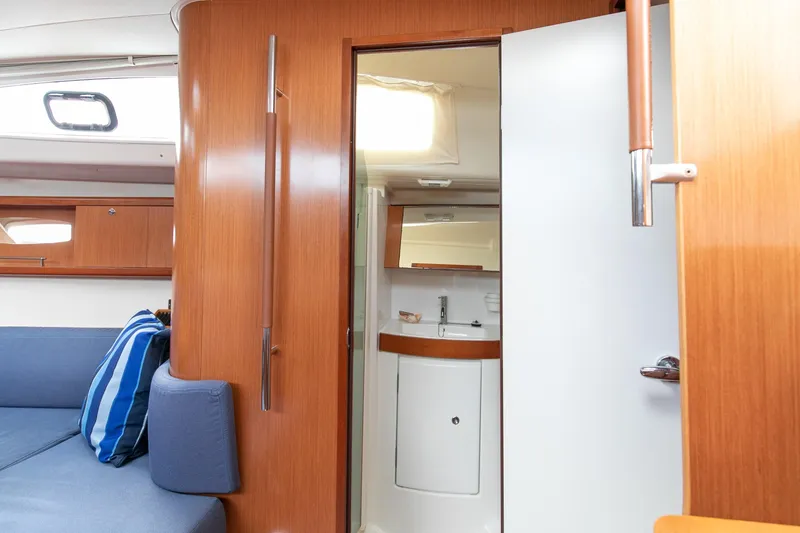 Slide: The Image of Interior of 2008 Beneteau 43 yacht, featuring wooden cabinetry and a compact bathroom. - 46