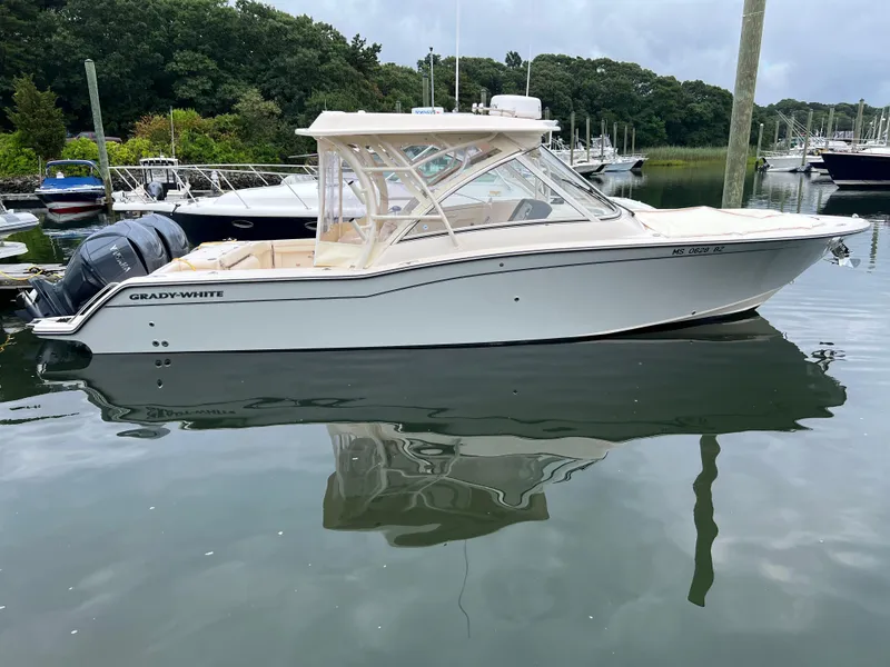 Slide: The Image of 2022 Grady-White Freedom 325 boat docked in a serene marina setting. - 0