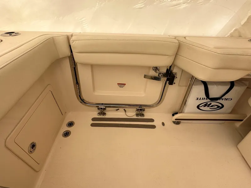 Slide: The Image of Interior of 2022 Grady-White Freedom 325 boat, featuring beige seating and storage compartments. - 11