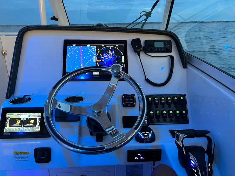 Slide: The Image of 2022 Grady-White Freedom 325 boat dashboard with navigation screens and controls. - 3
