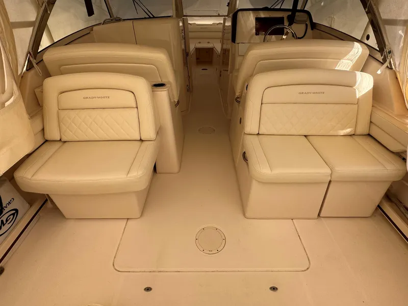 Slide: The Image of 2022 Grady-White Freedom 325 boat interior with beige seating and steering wheel. - 8