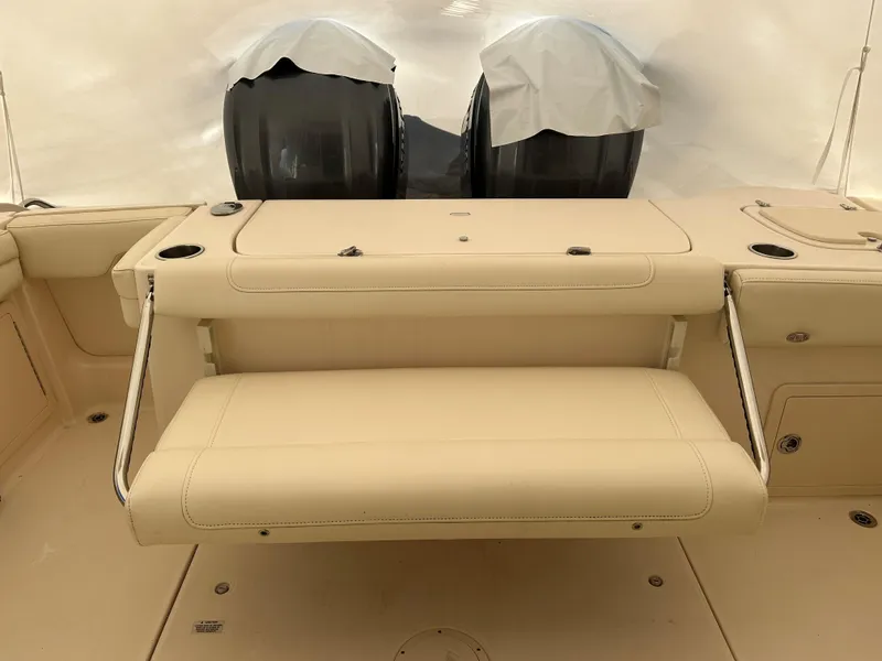 Slide: The Image of 2022 Grady-White Freedom 325 boat interior with beige seating and dual engines. - 9