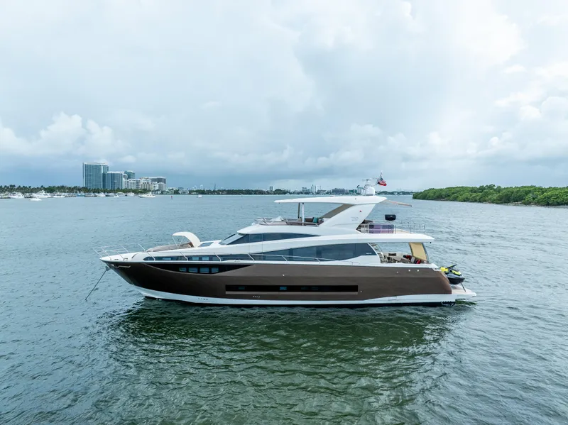 Slide: The Image of Luxury 2015 Prestige 750 yacht cruising on a calm, scenic waterway. - 10