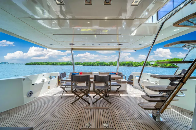 Slide: The Image of Luxurious 2015 Prestige 750 yacht deck with seating, overlooking serene waters and lush greenery. - 16