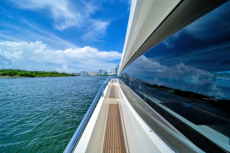 Slide: The Image of Prestige 750 yacht cruising on a sunny day, reflecting city skyline on water. - 18